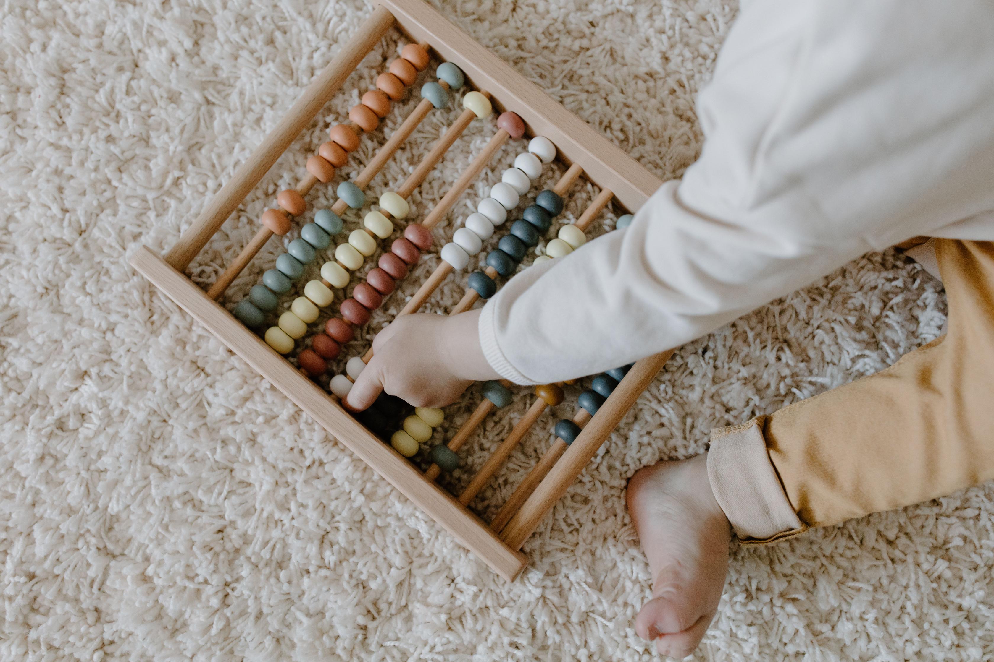 A child counting on a wooden abacus